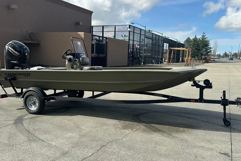 Slide: The Image of 2026 Tracker Grizzly 1860 CC boat on trailer, parked outdoors under a cloudy sky. - 10