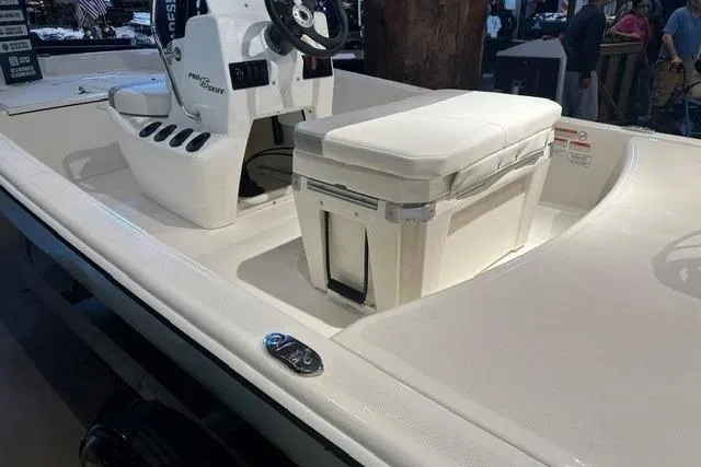 Slide: The Image of 2026 Mako Pro Skiff 15 CC boat interior with steering console and cushioned seating. - 11