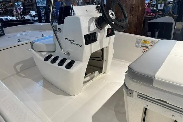 Slide: The Image of 2026 Mako Pro Skiff 15 CC boat interior with steering console and seating. - 10