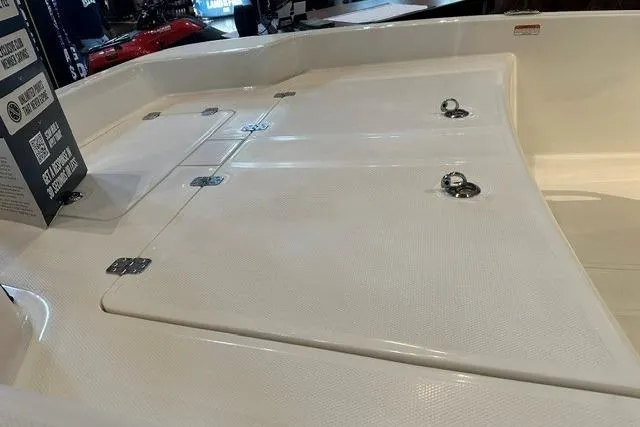 Slide: The Image of 2026 Mako Pro Skiff 15 CC boat deck with storage compartments and metal fixtures. - 9