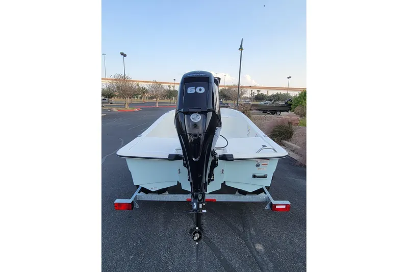 Slide: The Image of 2026 Mako Pro Skiff 15 CC boat with 60 HP outboard motor on trailer. - 14