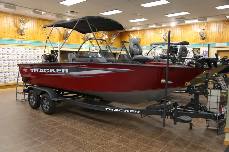 The Image of 2026 Tracker Targa V-19 Combo boat displayed indoors, featuring a sleek red design. - 0