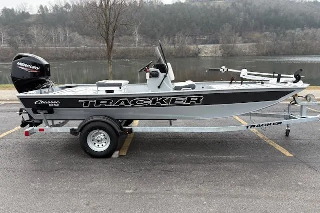 The Image of 2026 Tracker Bass Tracker Classic CC boat on trailer by a river. - 0