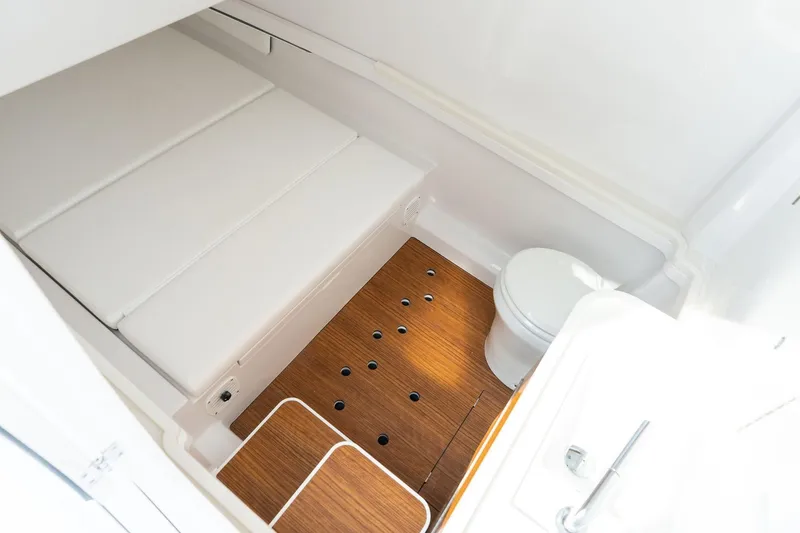 Slide: The Image of Compact bathroom in 2026 Phenom 37 boat with wooden flooring and white fixtures. - 7