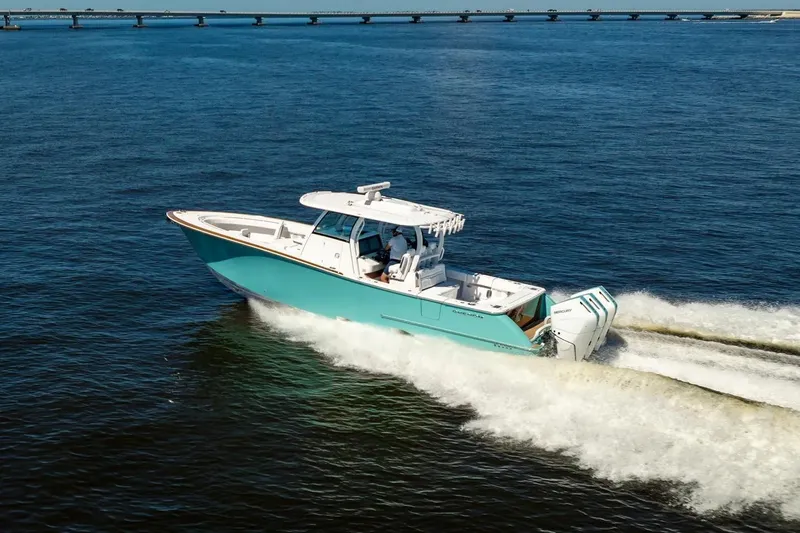 Slide: The Image of 2026 Phenom 37 boat cruising on open water with bridge in background. - 8