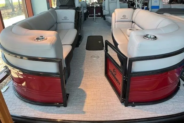 The Image of 2026 Regency 230 DL pontoon boat interior with plush seating and cup holders. - 0