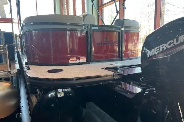 Slide: The Image of 2026 Regency 230 DL pontoon boat with Mercury outboard motor in showroom. - 4