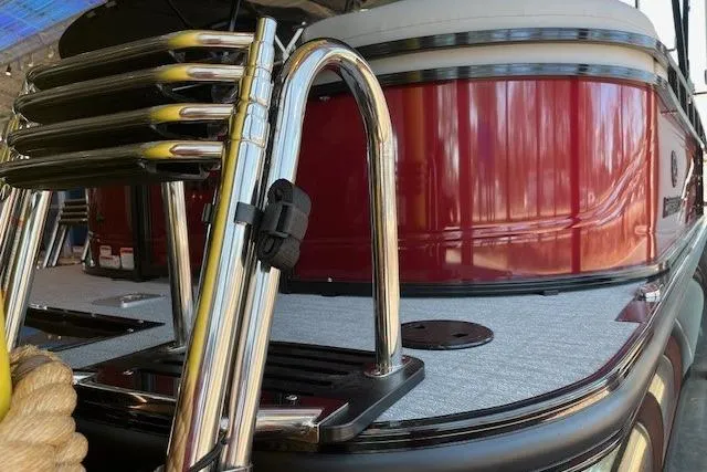 Slide: The Image of 2026 Regency 230 DL boat with chrome ladder and red exterior detailing. - 6