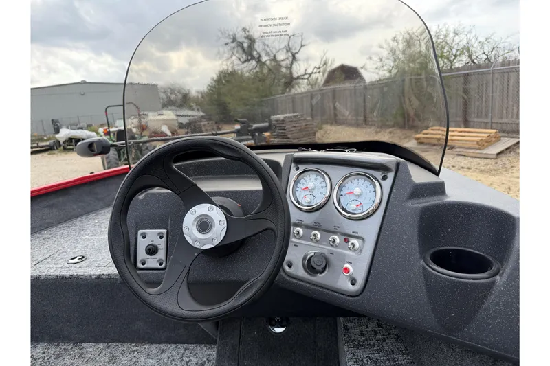 Slide: The Image of 2026 Tracker Pro Guide V-16 SC boat dashboard with steering wheel and gauges. - 44
