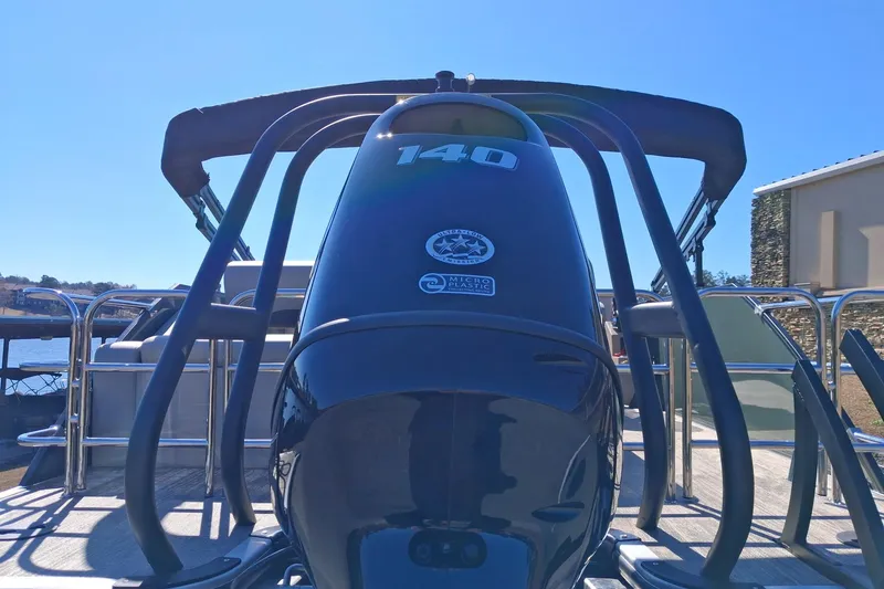 Slide: The Image of 2026 Bentley Pontoons Legacy 240 Swingback with powerful outboard motor, docked under clear sky. - 5