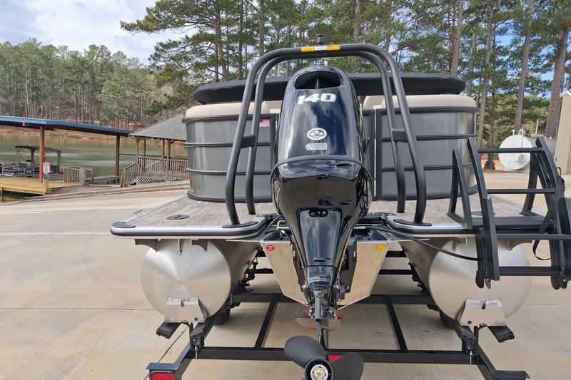 Slide: The Image of 2026 Bentley Pontoons Legacy 240 DL Navigator with powerful outboard motor, docked near a serene lake. - 3