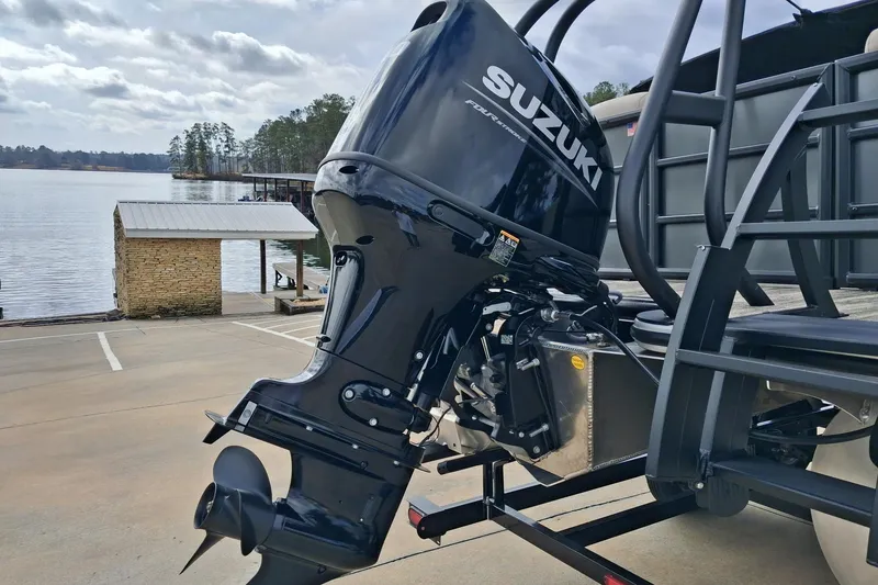 Slide: The Image of 2026 Bentley Pontoons Legacy 240 DL Navigator with Suzuki outboard motor by a lake. - 7