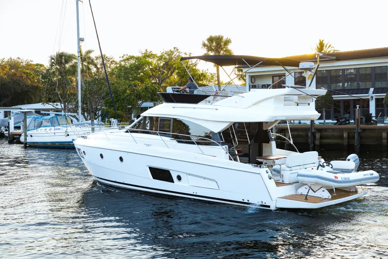 Slide: The Image of 2013 Bavaria Virtess 420 Fly yacht cruising near waterfront homes. - 2