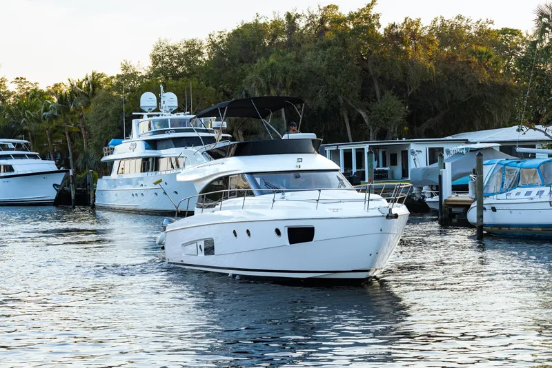 Slide: The Image of 2013 Bavaria Virtess 420 Fly yacht cruising in a marina with surrounding boats. - 5