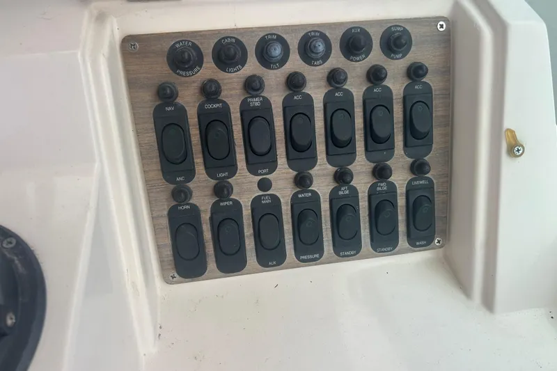 Slide: The Image of Control panel of a 1992 Grady-White Sailfish 252 boat with various switches. - 26