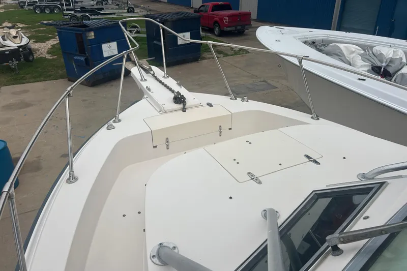 Slide: The Image of 1992 Grady-White Sailfish 252 boat deck with anchor chain, docked near blue dumpsters. - 30