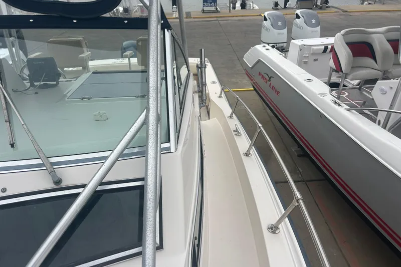 Slide: The Image of 1992 Grady-White Sailfish 252 boat docked beside another vessel. - 37