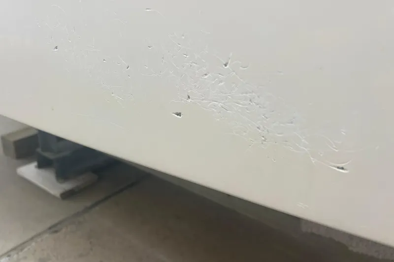 Slide: The Image of 1992 Grady-White Sailfish 252 hull with visible surface scratches and minor damage. - 44