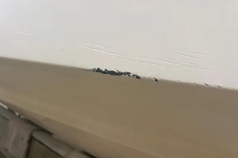 Slide: The Image of Close-up of 1992 Grady-White Sailfish 252 hull with minor paint damage. - 45