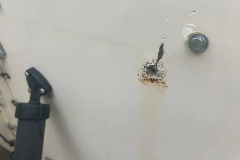 Slide: The Image of Damaged hull of 1992 Grady-White Sailfish 252 boat with visible hole and rust. - 46