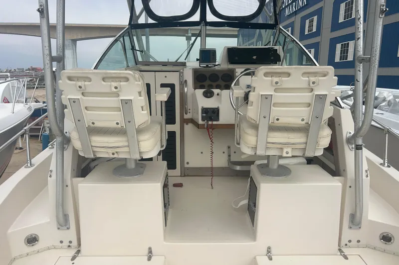 Slide: The Image of 1992 Grady-White Sailfish 252 boat cockpit with dual captain chairs and control panel. - 8
