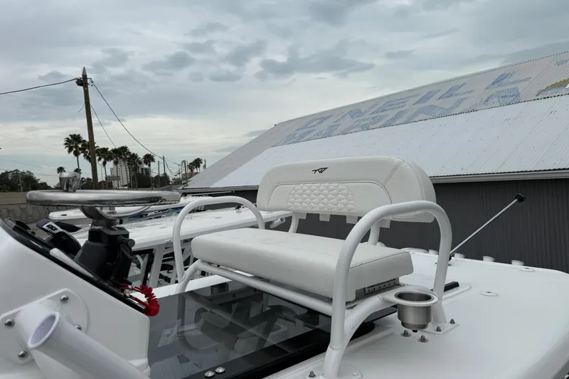 Slide: The Image of 2026 Tidewater 2700 Carolina Bay boat with white seating and steering wheel. - 11