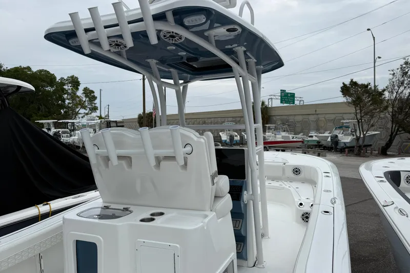 Slide: The Image of 2026 Tidewater 2700 Carolina Bay boat with T-top and console, parked in a marina. - 6