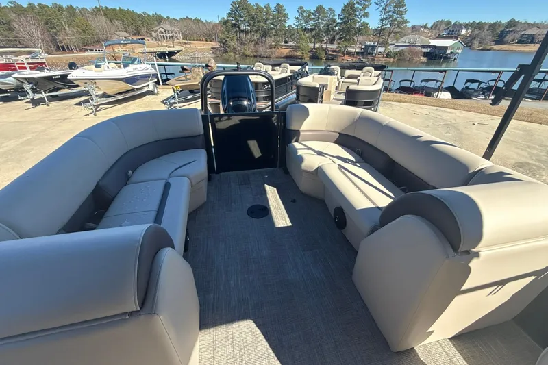 Slide: The Image of 2026 Bentley Pontoons Legacy 243 Navigator interior with spacious seating, docked by a scenic lake. - 8