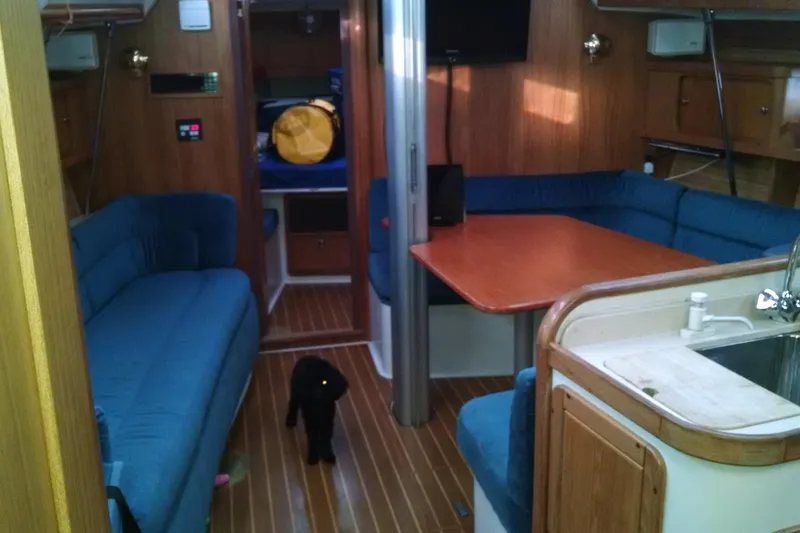 Slide: The Image of Interior of a 1999 Catalina 400 sailboat with blue seating and wooden finishes. - 11