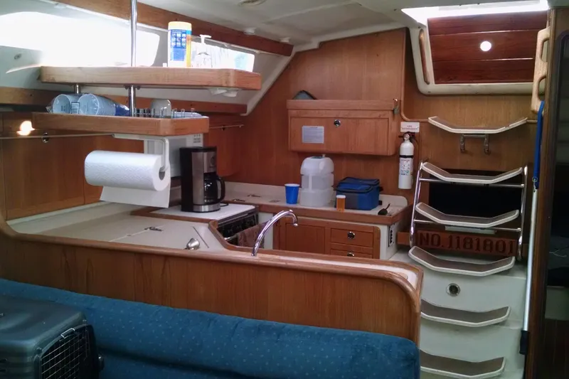 Slide: The Image of Interior of a 1999 Catalina 400 sailboat kitchen with wooden cabinetry and appliances. - 12