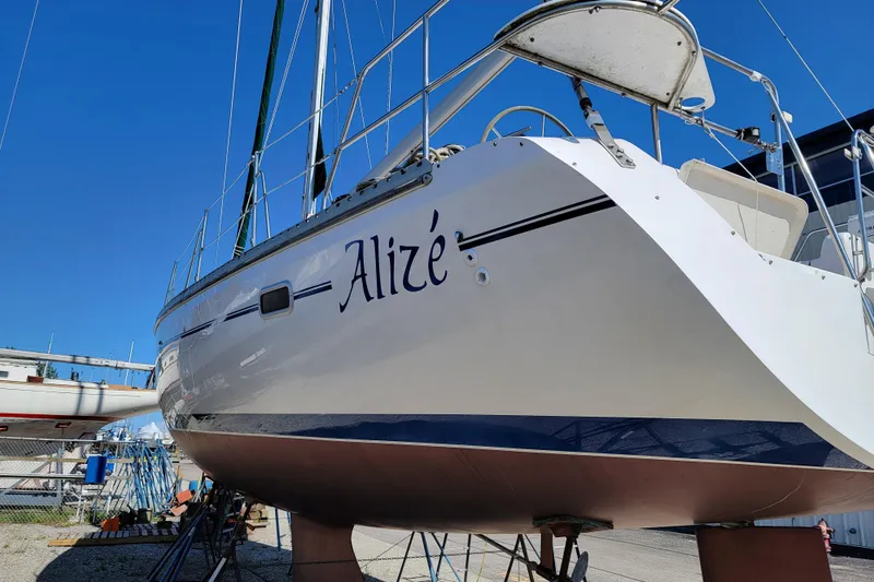 Slide: The Image of Catalina 400 sailboat from 1999 named "Alizé" on dry dock under clear blue sky. - 5
