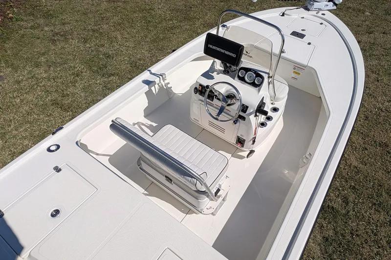 Slide: The Image of 2015 Mako 18 LTS boat interior with steering console and seating on grass. - 14