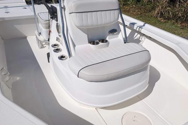 Slide: The Image of 2015 Mako 18 LTS boat interior with white seating and cup holders. - 15