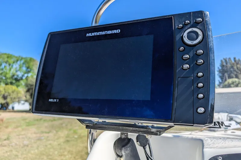 Slide: The Image of Humminbird Helix 9 fish finder on a 2015 Mako 18 LTS boat, clear blue sky background. - 18