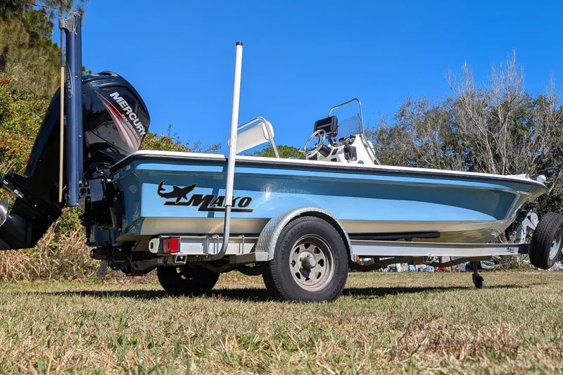 Slide: The Image of 2015 Mako 18 LTS boat on trailer, featuring Mercury outboard motor, parked on grass. - 4