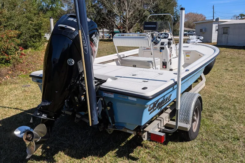 Slide: The Image of 2015 Mako 18 LTS boat on trailer with outboard motor, parked on grass. - 5