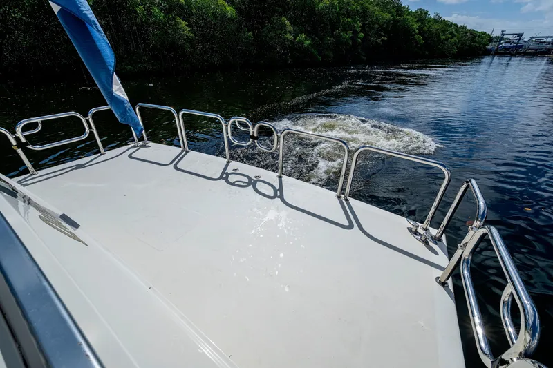 Slide: The Image of Ferretti Yachts 650, 1997 model, cruising on a serene river with lush greenery. - 10