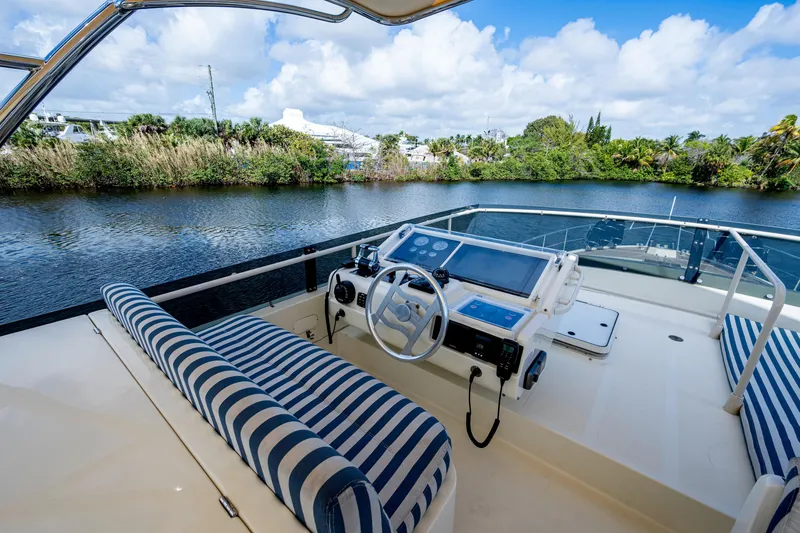 Slide: The Image of Cockpit view of 1997 Ferretti Yachts 650 with striped seating and scenic waterway. - 14