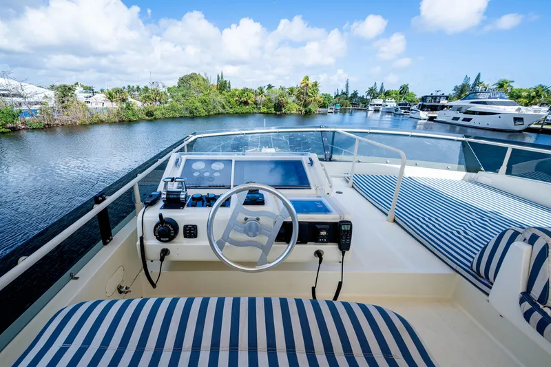 Slide: The Image of Cockpit view of 1997 Ferretti Yachts 650, featuring striped seating and serene waterway. - 16