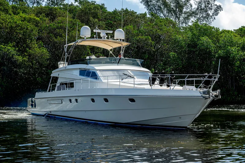 Slide: The Image of Luxurious 1997 Ferretti Yachts 650 cruising on calm waters, surrounded by lush greenery. - 2