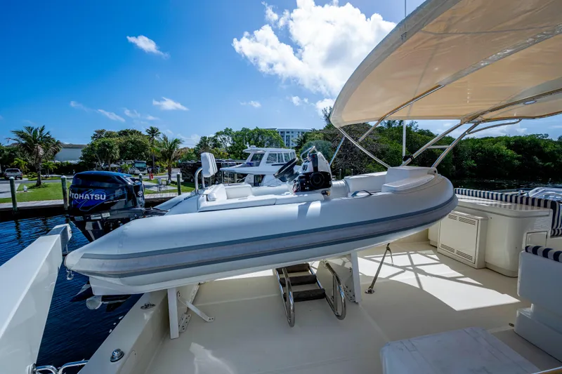 Slide: The Image of 1997 Ferretti Yachts 650 with inflatable boat on deck, sunny marina setting. - 20