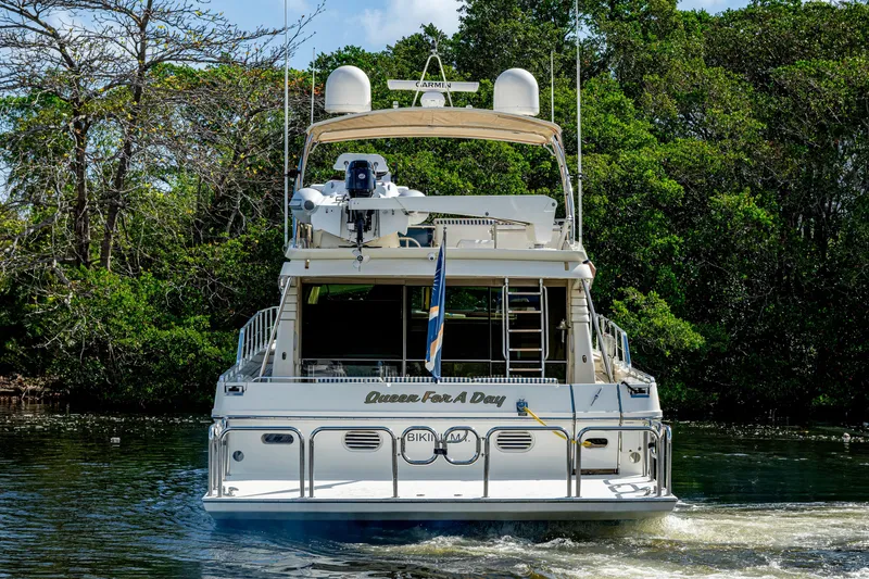 Slide: The Image of 1997 Ferretti Yachts 650 cruising on a serene waterway, surrounded by lush greenery. - 3