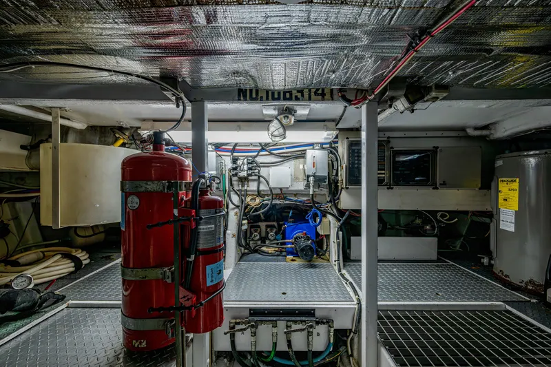 Slide: The Image of Engine room of a 1997 Ferretti Yachts 650, featuring fire extinguishers and control panels. - 30