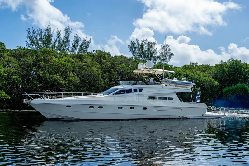 Slide: The Image of 1997 Ferretti Yachts 650 cruising on a serene waterway, surrounded by lush greenery. - 5
