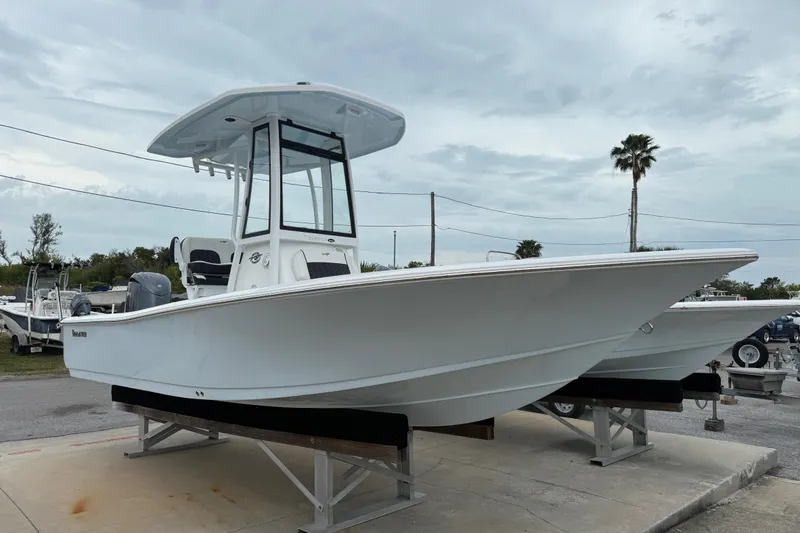 The Image of 2026 Tidewater 2210 Carolina Bay boat displayed on a stand under cloudy skies. - 1
