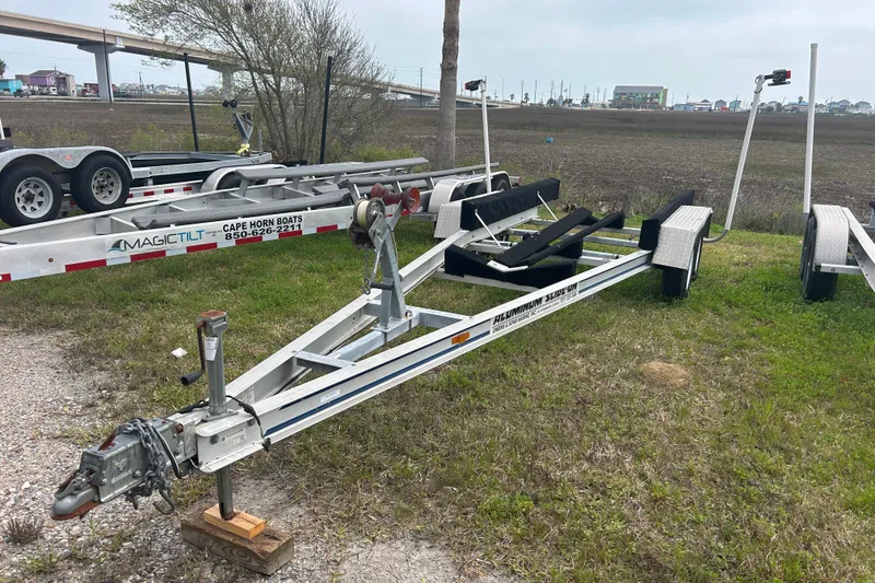 Slide: The Image of Boat trailer for 2005 Boston Whaler 205 Eastport, parked on grassy area near highway. - 27