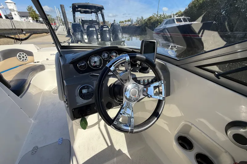 Slide: The Image of 2018 Stingray 204 LR boat cockpit with steering wheel and dashboard controls. - 15