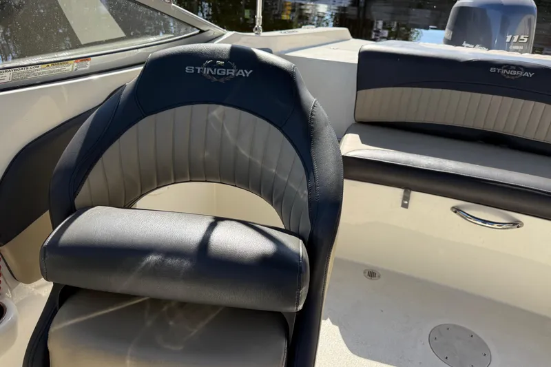 Slide: The Image of 2018 Stingray 204 LR boat interior with black and gray seating, showcasing luxury design. - 19
