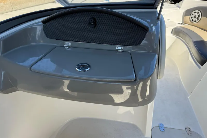 Slide: The Image of 2018 Stingray 204 LR boat interior with storage compartment and seating area. - 23