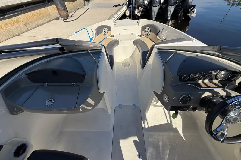 Slide: The Image of 2018 Stingray 204 LR boat interior with dashboard and seating area. - 24